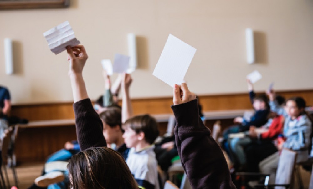 Jugendliche halten Karten zur Abstimmung in die Höhe