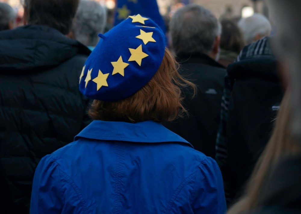 Eine Frau ist von hinten zu sehen, sie trägt eine blaue Mütze mit gelben Sternen.