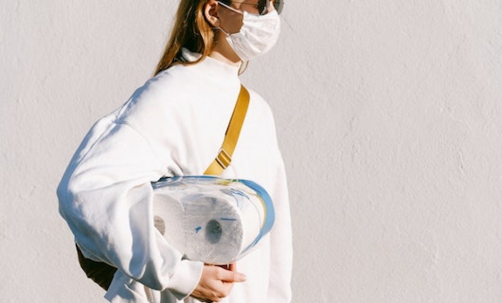 Junge Frau mit Maske und Toilettenpapier.