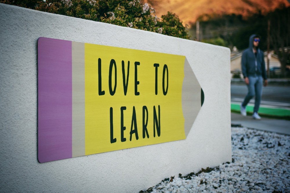 Schild in der Form eines Stiftes mit der Aufschrift: Love to learn.